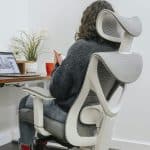 Pessoa sentada com boa postura em cadeira ergonômica em frente ao computador - Nunes Consultoria Informática