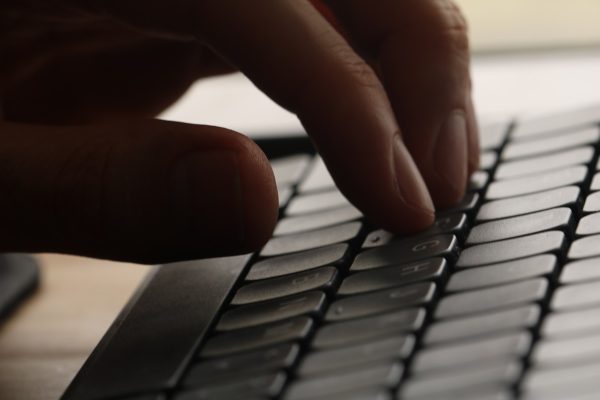 Close-up de m&atilde;os digitando no teclado, ilustrando postura das m&atilde;os e preven&ccedil;&atilde;o de LER/DORT - Nunes Consultoria Inform&aacute;tica
