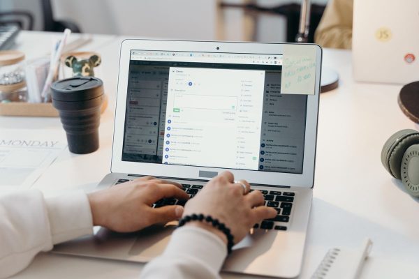 Pessoa configurando ferramenta digital em notebook em ambiente de escrit&oacute;rio claro