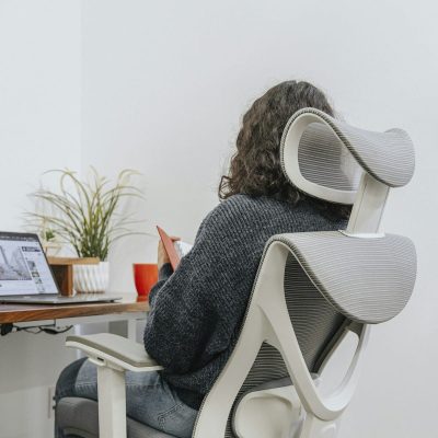 Pessoa sentada com boa postura em cadeira ergon&ocirc;mica em frente ao computador - Nunes Consultoria Inform&aacute;tica