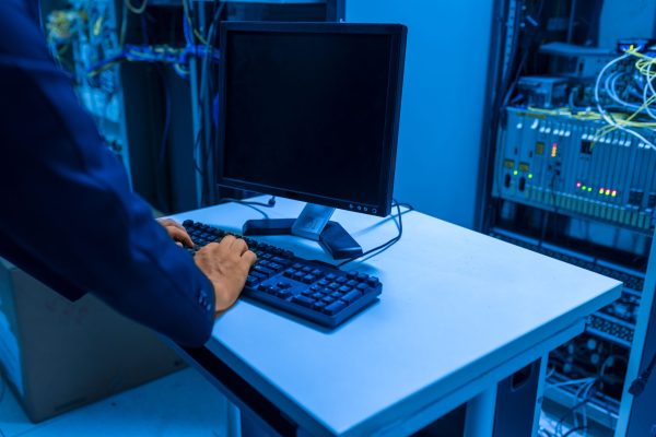 Técnico de TI em sala de servidores Técnico de TI trabalhando em sala de servidores - Nunes Consultoria Informática